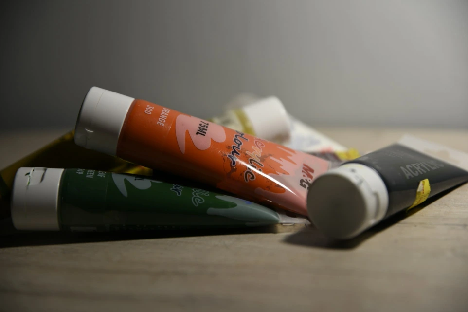 tiga tabung pasta gigi yang terletak di atas meja kayu